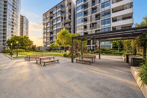 A modern apartment complex with multiple high-rise buildings, outdoor seating areas, and well-maintained landscaping.
