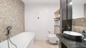 Un baño con bañera, inodoro y lavamanos.