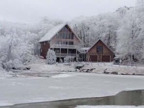 A two-story building with a large balcony and a garage. - Lakefront luxury awaits at Beech Mountain Ski and Lake Chalet! (Beech Mountain)
