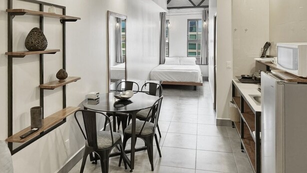 Een moderne keuken met een eethoek, een bed en uitzicht op de stad.