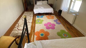 A bedroom with a bed, a chair, a radiator, and a window. - Room-goat House Near the Airport (Arnavutköy)