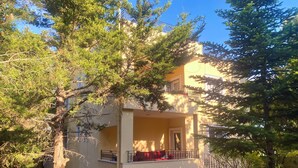 A two-story building with a balcony, surrounded by trees. - Room-goat House Near the Airport (Arnavutköy)