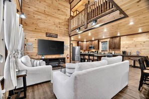 A cozy cabin interior with a living room, a dining area, and a kitchen. - Family Cabin Retreat | Hot Tub, Decks & Fire Pit (Gatlinburg)