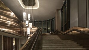 A modern interior with a staircase, metal railings, and hanging lights. - Guiyanghengshiji Hotels (Guiyang)