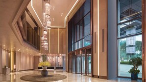 A modern lobby with a central chandelier, large windows, and a reception desk. - Guiyanghengshiji Hotels (Guiyang)