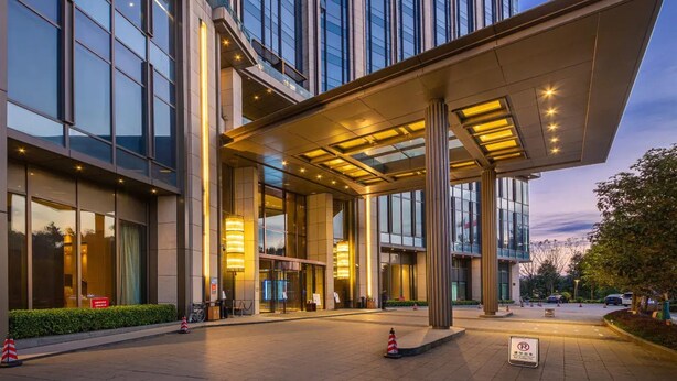 A modern hotel entrance with a covered walkway, large windows, and a well-lit facade. - Guiyanghengshiji Hotels (Guiyang)
