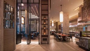 A modern restaurant with a central open space, wooden flooring, and a variety of seating arrangements. - Guiyanghengshiji Hotels (Guiyang)