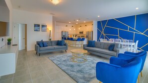 A modern living room with two sofas, a coffee table, and a dining area with chairs and a table. - Value Edge (Kissimmee)
