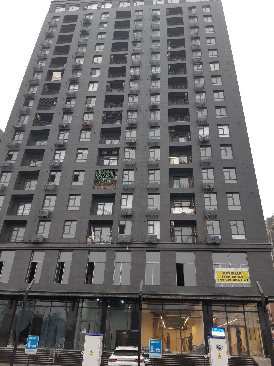 Un edificio alto con varios balcones y una entrada a nivel de calle.