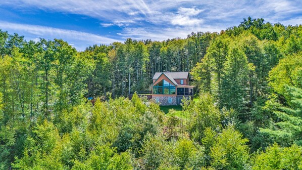 Une maison moderne entourée d’une forêt dense.