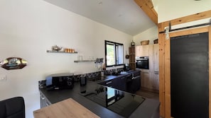 A modern kitchen with a black countertop, wooden cabinets, and a blackboard.