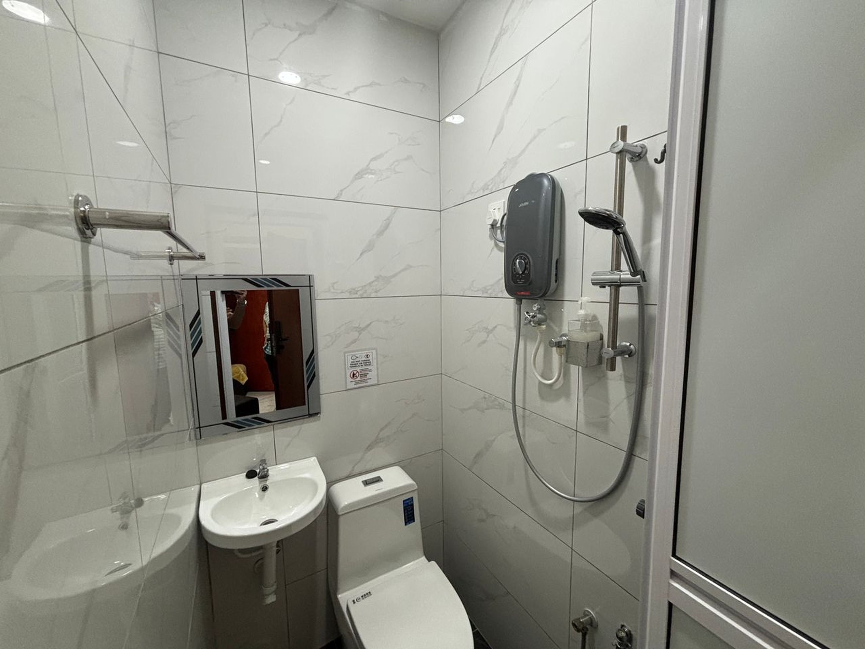 A modern bathroom with a toilet, sink, and shower.
