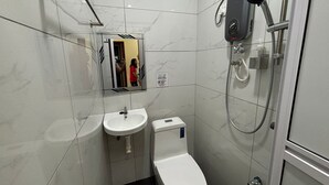 Baño con inodoro, lavabo y ducha.