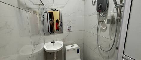 A bathroom with a toilet, sink, and shower.