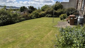 A well-maintained lawn with a clear view of the sky and distant hills. - Stylish River View Stay Sleeps 6 (Dundee)