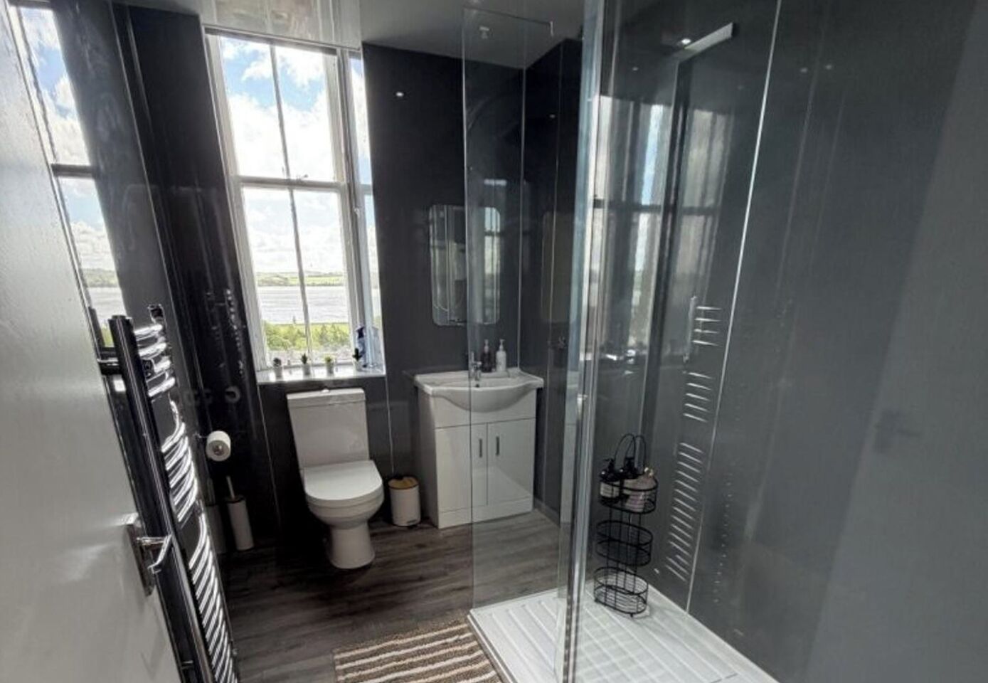 Een moderne badkamer met toilet, wastafel en douche.