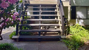 Een twee verdiepingen tellend huis met een voortuin, een brievenbus en het nummer 2121 op de deur.