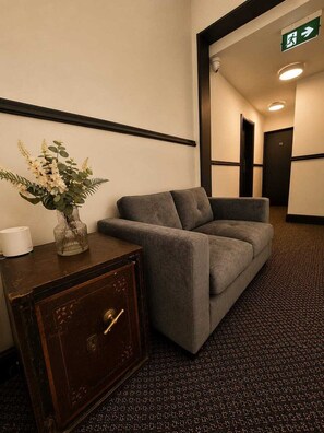 A hotel lobby with a sofa, a decorative vase, and a safe. - Inviting a Double Room for Business or Leisure (Liverpool)