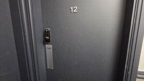 A dark-colored elevator door with the number 12, a push button, and a metal plate with the word 'PUSH'. - Double and Single Room with Private Bathroom (Liverpool)