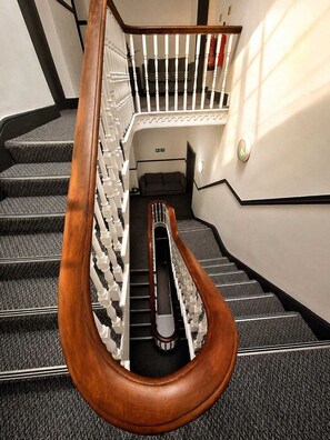 A staircase with a wooden handrail and white balusters, carpeted steps, and a landing area with a door. - Comfortable En-Suite Double Room in Liverpool (Liverpool)