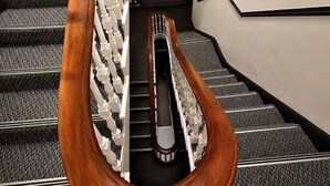 A staircase with a wooden handrail and white balusters, carpeted steps, and a landing area with a door. - Contemporary Double Room with Private Bathroom (Liverpool)