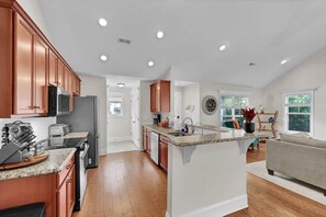 A kitchen with wooden cabinets, a granite countertop, and a central island.