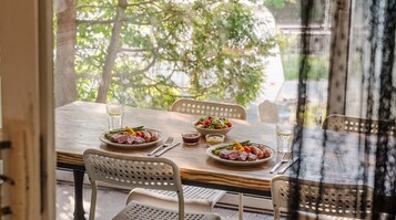 Una mesa de comedor con platos de comida, vasos y cubiertos.