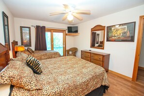 A bedroom with two beds, a ceiling fan, a television, and a framed picture on the wall. - Oceanside, Priv Pool, Hot Tub, Rec Rm-DL102, Aqua Duck (Duck)