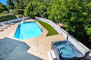 A rectangular swimming pool with a hot tub, surrounded by a white fence and lush greenery. - Oceanside, Priv Pool, Hot Tub, Rec Rm-DL102, Aqua Duck (Duck)