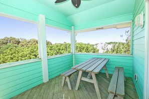 A turquoise room with a wooden bench and a table, large windows, and a view of greenery. - Oceanside, Priv Pool, Hot Tub, Rec Rm-DL102, Aqua Duck (Duck)