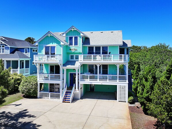 A multi-story house with a balcony on each floor, a front porch, and a driveway. - Oceanside, Priv Pool, Hot Tub, Rec Rm-DL102, Aqua Duck (Duck)