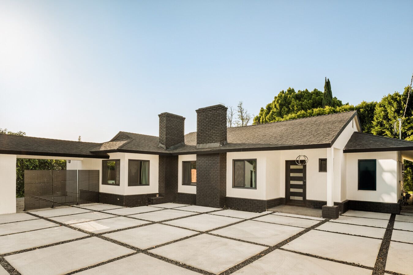 A modern two-story house with a covered patio area.
