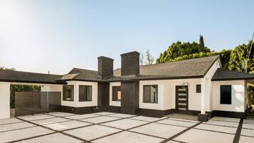 A modern two-story house with a covered patio area.