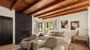 A cozy bedroom with a fireplace, a bed, a sofa, and a nightstand. - Executive 4BR/4BA Home Near Universal Studios (Los Angeles County)