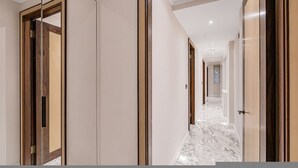 En korridor med marmorgolv, trädörrar och en modern inredningsstil.