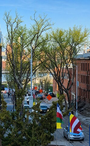 Une rue de la ville bordée d’arbres, avec des voitures et des immeubles.