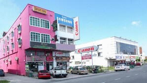A pink building with a Canon store and a Samsung store. - Hotel O D'noor (Kota Bharu)