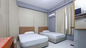 A room with two beds, a desk, an air conditioning unit, and a mirror. - Hotel O D'noor (Kota Bharu)