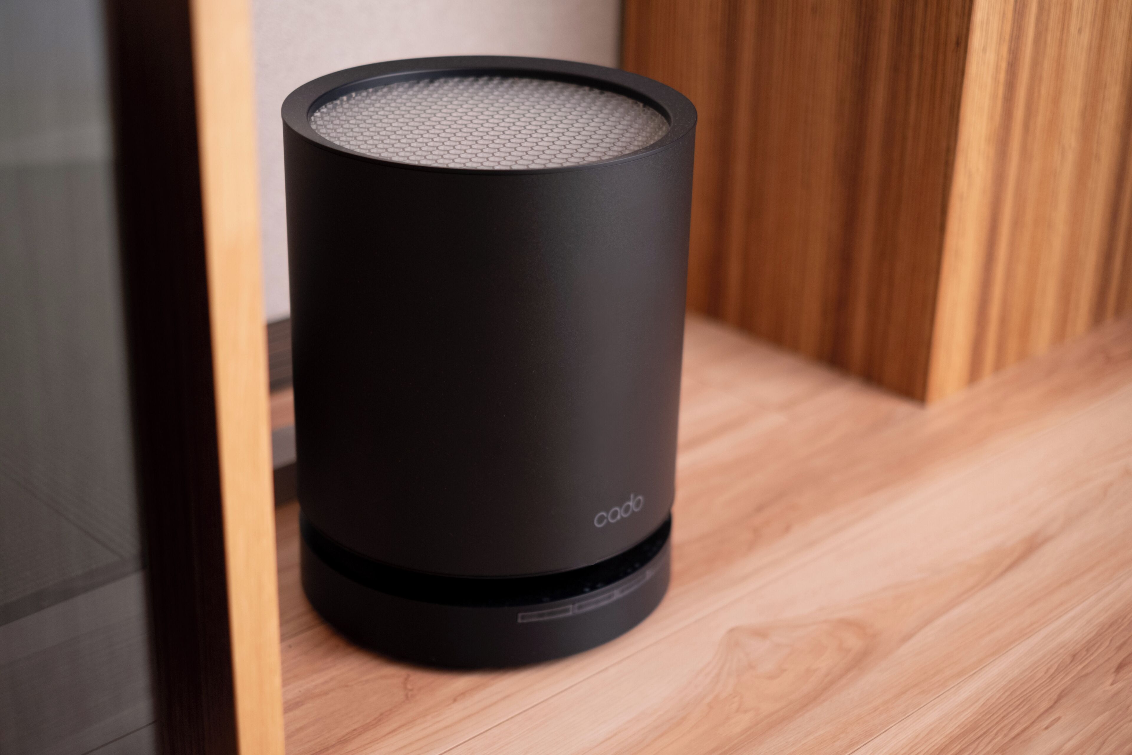 A black speaker with the brand name 'coda' on a wooden floor.