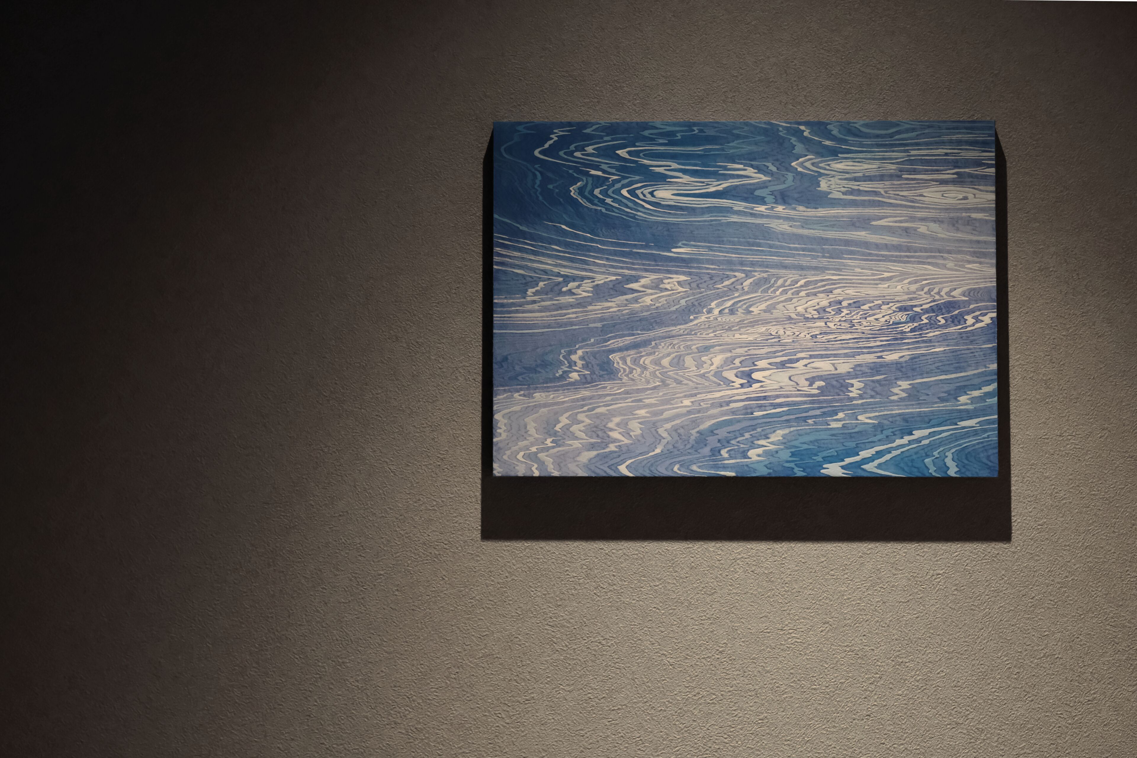 Un objet rectangulaire présentant un motif marbré sur un mur à texture.