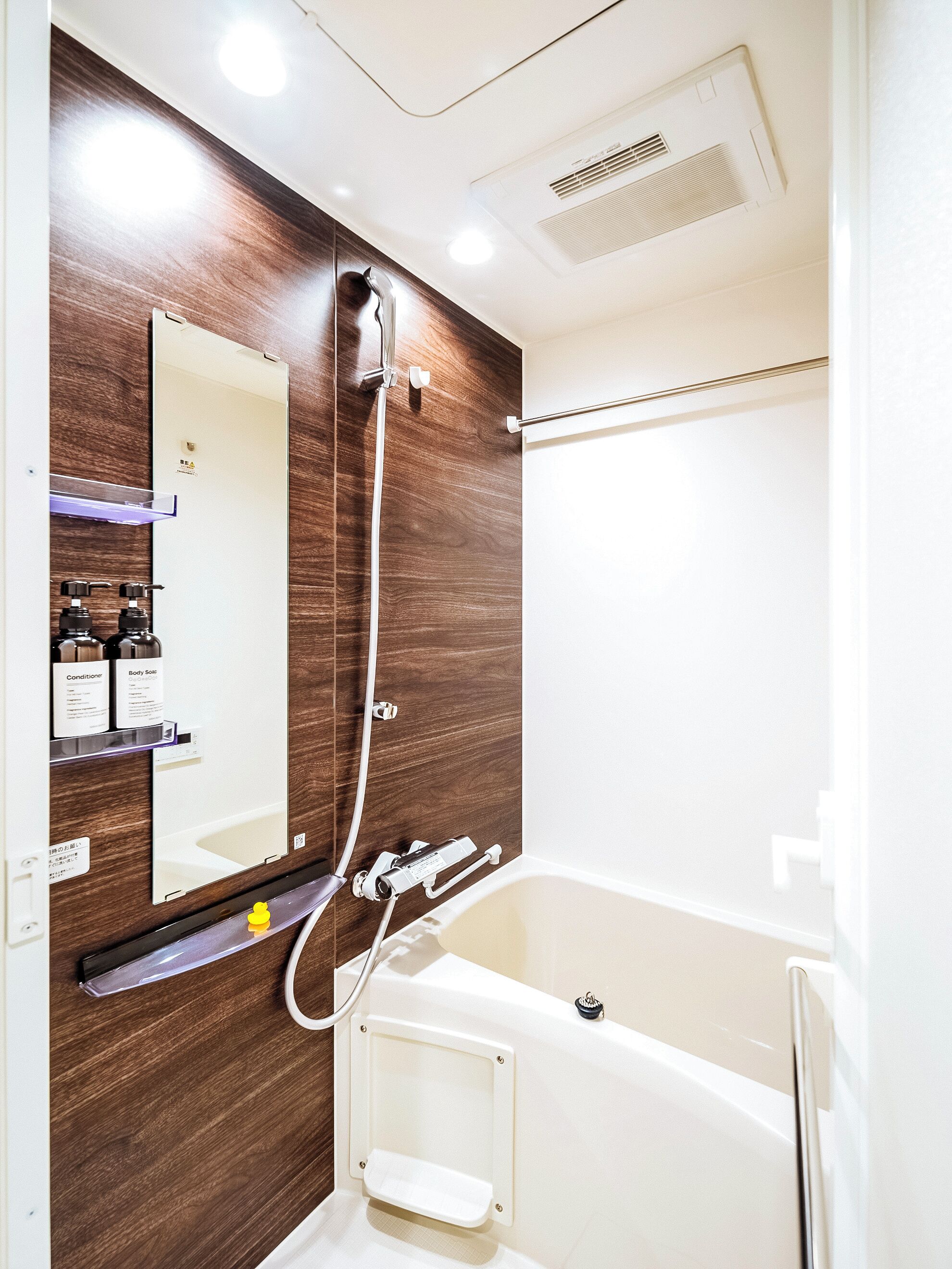 Une salle de bain moderne avec un meuble-lavabo en bois, un miroir, une douche et une baignoire.