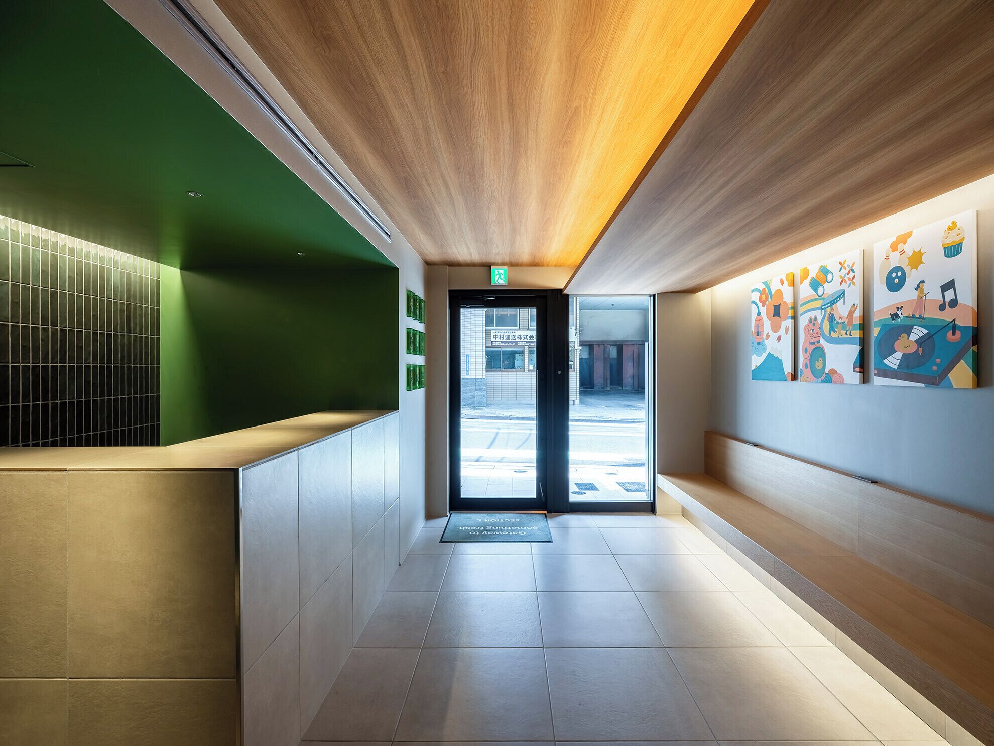 A modern interior with a reception desk, a wooden ceiling, and colorful artwork on the walls.