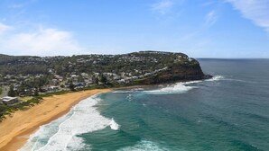 Un pueblo costero con playa, océano y edificios residenciales.