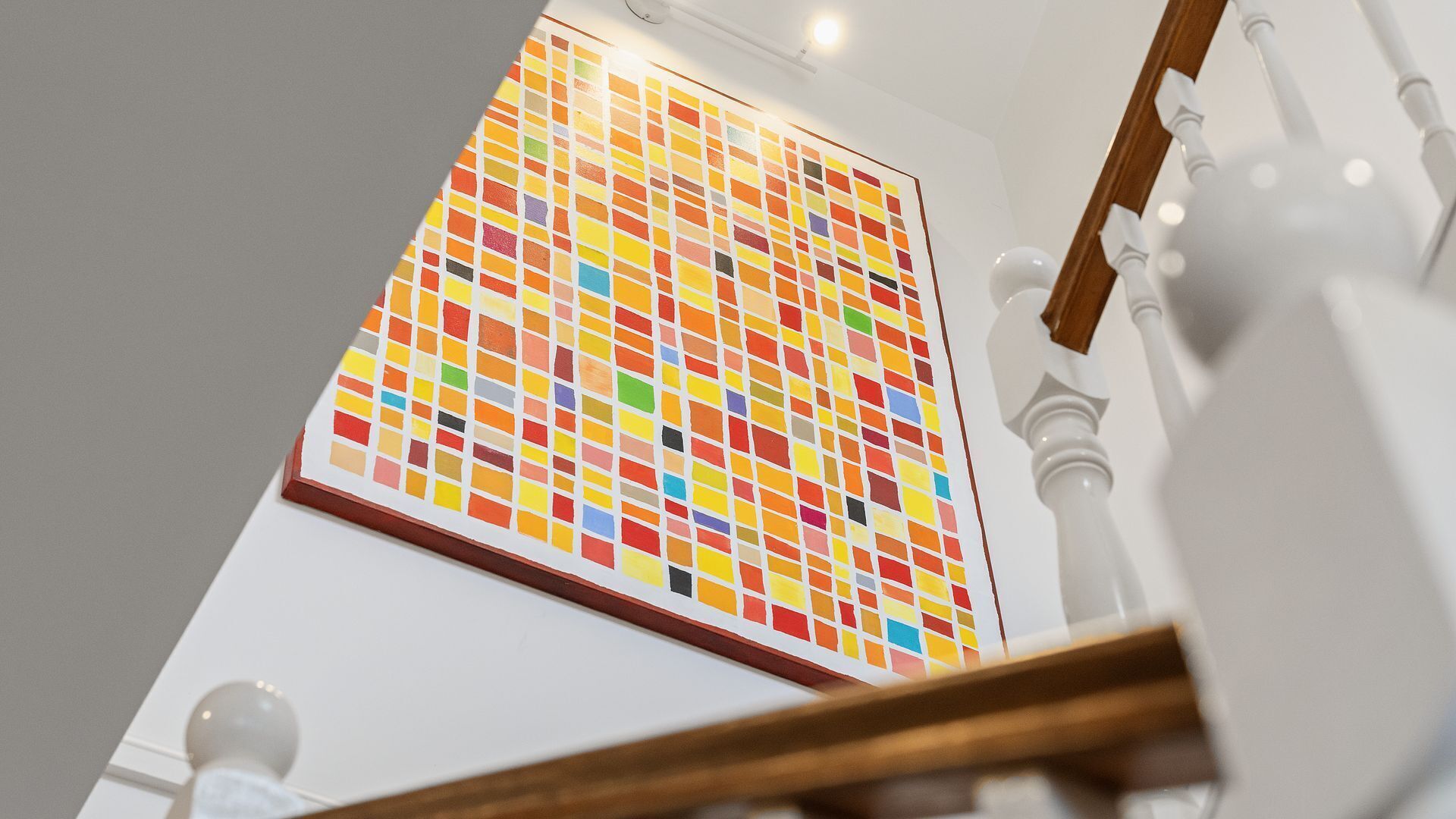 A staircase with a colorful mosaic wall at the top.