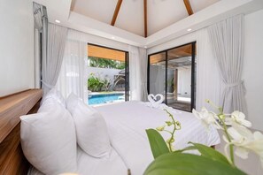 A bedroom with a bed, a view of a swimming pool, and a sliding glass door. - Anchan Villas Phuket - Private 4 BR Signature Pool Villa by Escape Villas (Phuket)