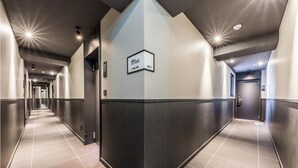 A modern hotel corridor with a sign indicating 'IN-HOUSE STYLE 2023'.