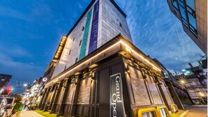 A modern building with a prominent sign for 'Grand Opening' and a vertical banner with the text '2018'.