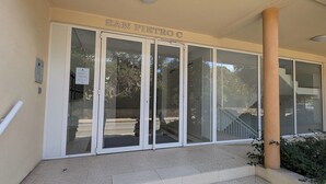 Une entrée d’immeuble avec une enseigne indiquant « SAN PIEDRO C » et un panneau « INTERDICTION DE PUBLICITÉ » sur la porte.