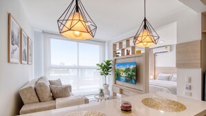 A modern living room with a sofa, a coffee table, a TV, and pendant lights. - Edificio Miro Guadalupe (Cali)