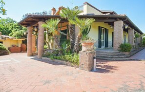 A Mediterranean-style building with a brick facade, a covered porch with columns, and a landscaped entrance. - Amazing home in Paestum with WiFi (Paestum)